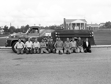 Fuquay-Varina Rural Fire Department firemen and equipment, fire truck in 1957. Photo taken on Academy Street in front of the Robert E. Prince Home, Fuquay-Varina, NC. From the Heulon Dean Photo Collection, PhC.133, North Carolina State Archives, call #: PhC133_1957_142_A. Fuquay-Varina Rural Fire Department firemen and equipment, fire truck in 1957. Photo taken on Academy Street in front of the Robert E. Prince Home, Fuquay-Varina, NC. From the Heulon Dean Photo Collection, PhC.133, North Carolina State Archives, call #: PhC133_1957_142_A.