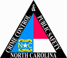 A triangular depiction of the North Carolina flag.  A thick black triangle outlines the flag and words on the triangle read "Crime Control & Public Safety North Carolina."