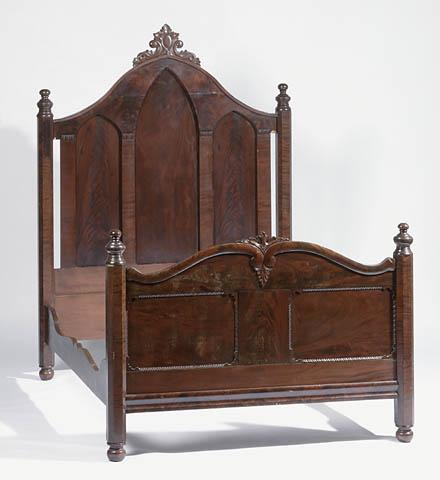 A large bed frame in a gothic style.