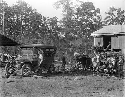 Cutting up corn for feed, using automobile for power about 1912.