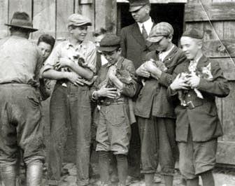 Students holding baby pigs, Farm School, 1908. Image courtesy of Warren Wilson Archives. 