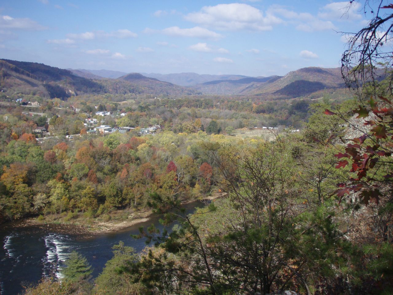 A view of Hot Springs, NC. A wooded view with a river in the foreground.