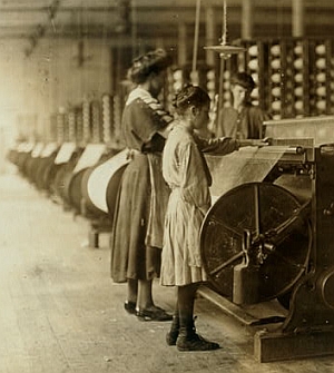 "Girls running warping machines in Loray mill, Gastonia, N.C. Many boys and girls much younger. Boss carefully avoided them, and when I tried to get a photo which would include a mite of a boy working at a machine, he was quickly swept out of range. 'He isn't working here, just came in to help a little.' Location: Gastonia, North Carolina. Taken in November 1908 by National Child Labor Committee (U.S.)