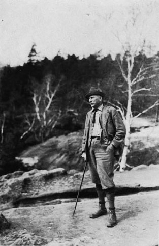 Kallitype photograph of Carl Alwin Schenck posing on a rocky outcrop