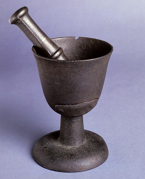 Cast iron Mortar and pestle. Mouth of Mortar tapers to bottom of footed base. Mortar is one piece with a repair bolted on outside. Mortar has a small chip in mouth. Pestle has rounded ends that slope towards middle where a raised band encircles pestle. 
