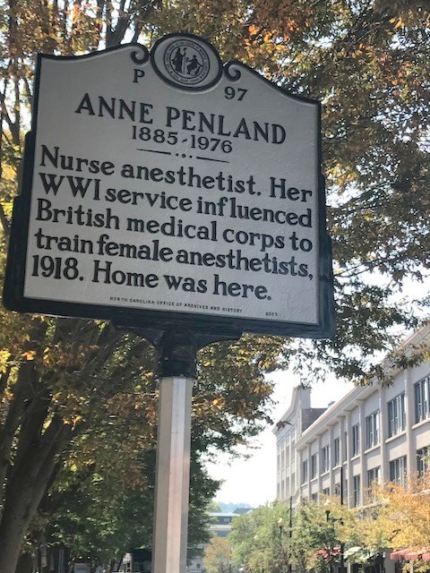 Anne Penland placard in Asheville. A tree is in the background. The placard details her life.