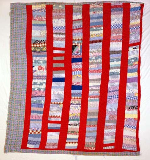 This is a photograph of a quilt made by Eliza Arrington, an African American quilter living in Cary, N.C. around 1930 to 1939. The quilt was pieced in strong and irregular large strips of cloth. It may have been made from a combination of strips of fabric from clothing and feed sacks. This quilt is from the collections of the N.C. Museum of History.