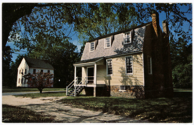 The Owens House a two story home with stairs leading to the front door. It has two chimneys 