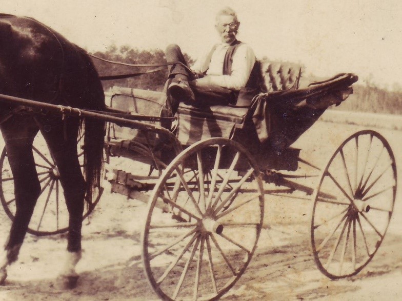 Photograph of Amos Cox in a Hunsucker Buggy, manufactured by the A.G. Cox Manufacturing Company. Used by permission.