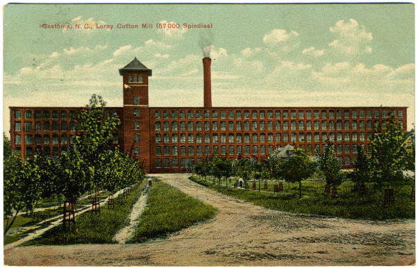 A post card depicting the Loray Textile Mill. It is a large, 5 story, brick building with a central tower and smokestack. Trees are in front. 