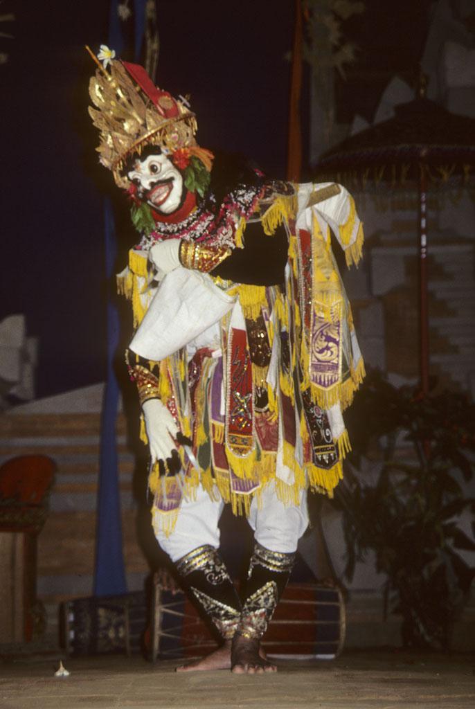 <img typeof="foaf:Image" src="http://statelibrarync.org/learnnc/sites/default/files/images/bali_239_0.jpg" width="686" height="1024" alt="Male masked dancer bows forward slightly and lifts front of tunic" title="Male masked dancer bows forward slightly and lifts front of tunic" />