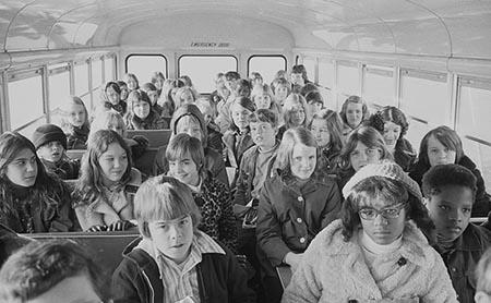 Two African American children and more than thirty white children riding in a school bus from the suburbs to an inner city school, Charlotte, North Carolina (1973).