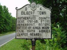 This is an image of the North Carolina Highway Historical Marker O-4 Gilbert Town. The text on the marker reads "O-4 Gilbert Town. Rutherford County Seat 1781-85. Stood hereabout before Battle of Kings Mountain both armies camped nearby.