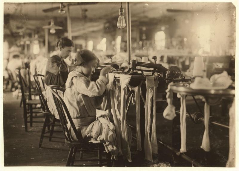 A child works in a hosiery mill. Very young, like four or five.