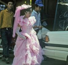 <img typeof="foaf:Image" src="http://statelibrarync.org/learnnc/sites/default/files/images/vietnam_145.jpg" width="1024" height="975" alt="Bride walks through street in lacy pink wedding dress and high gloves at Mytho" title="Bride walks through street in lacy pink wedding dress and high gloves at Mytho" />