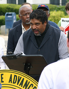 The Reverend Dr. William Barber II, president of the N.C. N.A.A.C.P., speaking across from the legislature building in Raleigh, 2012. Image from Flickr user NC Justice Center.