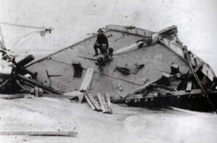 The Priscilla wrecked during the hurricane of 1899. Rasmus Midgett, sitting on the wreckage, saved ten people from the ship during the hurricane.  Image courtesy of the NC Office of Archives and History via East Carolina University.