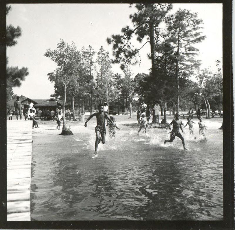 Children racing into the water at the beach area, circa 1963. Jones Lake State Park opened in the summer of 1939 as the first state park for African Americans, and achieved immediate popularity. In later years the park, like all other North Carolina State Parks, became fully integrated.