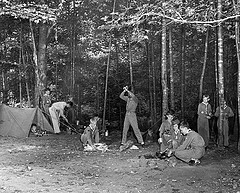 Boy scouts team of Walters Plant, no date (c.1960), location unknown, showing Boy Scouts chopping wood and making camp in the woods. From Carolina Power and Light (CP&L) Photograph Collection (Ph.C.68), North Carolina State Archives, call #:  PhC68_1_508_3. 