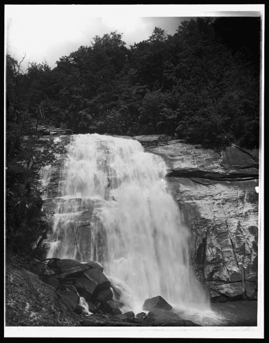 Image of Rainbow Falls, today in Gorges State Park. Photograph ca. 1890-1906. From the Library of Congress Prints and Photographs Online Collection. Item is labeled [Saphhire, N.C., Horse Pasture Falls]. Note that the printed image appears to be a reverse print of the original negative. The horizontal fissure near the top of the falls is actually located on the left, when facing the falls, and a pile of rock and boulders, prominent in the left foreground of the image is actually on the right side of the view when facing the falls.