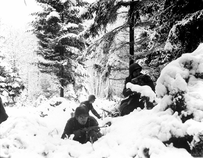 American soldiers in the 75th Division take cover in the deep snow of Belgium's Ardennes Mountain region during the Battle of the Bulge.