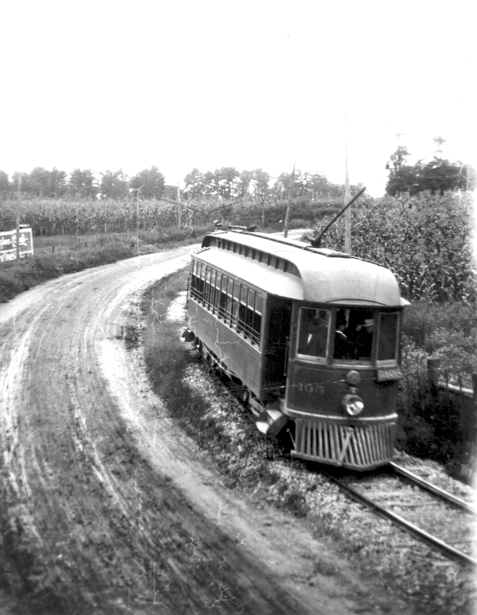 Trolley on its rails beside a dirt road.