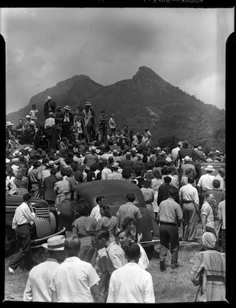 Singing on the Mountain celebration. Many people are gathered in front of a mountain. Black and white.