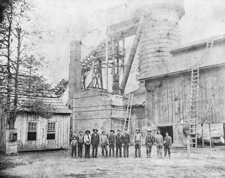 Employees stand in front of the furnace of the Cranberry Iron Mine, ca. 1895. North Carolina Collection, University of North Carolina at Chapel Hill Library.