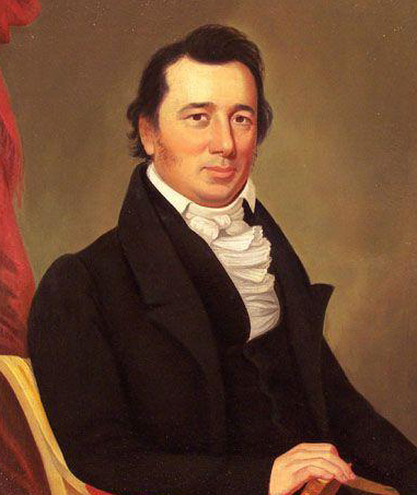 William Augustus Blount. He is depicted seated. He is wearing a coat and collared shirt. He has medium length hair and is smirking.