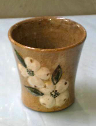 A 1940 cup by Ernest Auburn Hilton, decorated with raised white dogwood blossoms. "Cup, Accession #: H.1969.144.14." 1940. North Carolina Museum of History.