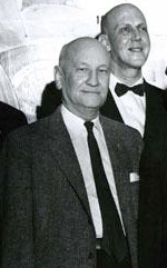 A 1958 photograph of McDaniel Lewis, when he was a member of the Executive Board of the N.C. Department of Archives and History. Behind him is Dr. Christopher Crittenden, head of the department. Image from the North Carolina Museum of History.