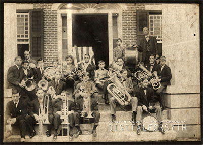 Photograph of B. J. Pfohl and the Salem Band in front of Main Hall at Salem College [date unknown]. B J. Pfohl is standing in the right rear of the image. From the collections of Forsyth County Public Library, Digital Forsyth, Winston-Salem, North Carolina.  Used by permission from the Forsyth County Public Library. 