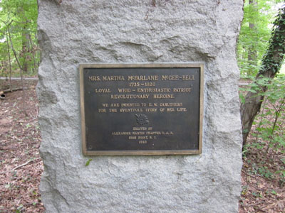 A large rectangular granite block atop a granite base. There is a plaque in the center with an inscription.