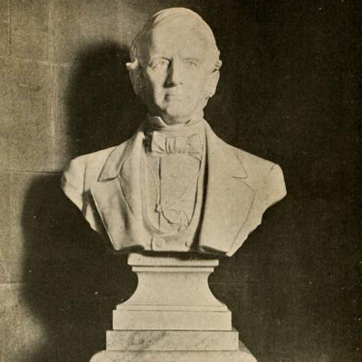 A stone bust of Graham, wearing a suit.