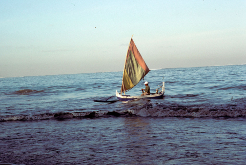 Fisherman in small sailboat near Kuta Beach