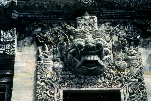 Carved stone guardian face over entrance gate at Pura Kehen Temple, Bali