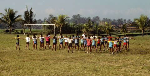 Middle school students doing morning exercises in field