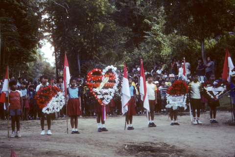 Line of children hold flags and wreaths at Independence Day, August 17, 1986