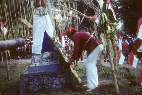 Man lays wreath at stone memorial on Independence Day, August 17, 1986