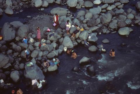 Bathing party among boulders in stream as seen from above