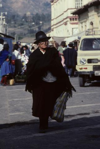 An old woman walks through the market of Saquisilí, Ecuador