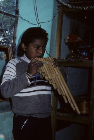 A boy plays a traditional flute in Otavalo, Ecuador