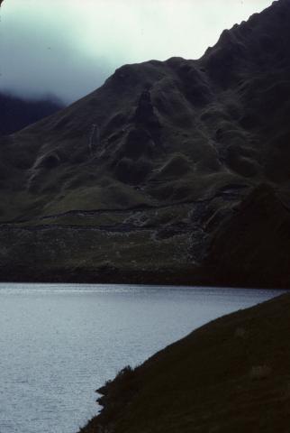 A paramo hillside rises from a lake near Otavalo, Ecuador