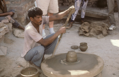 A potter near Jodhpur, India, turning the wheel with a stick