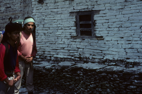 Nepalese trekking guides in front of a white-washed wall