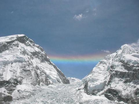 A rainbow bridges Mount Everest and Mount Nuptse