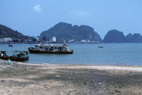 Ferry boats in the harbor at Bai Chay bordered by beach and mountains