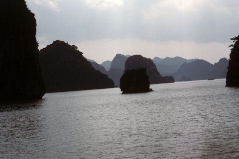 Grey sea view of rocky island silhouettes in Halong Bay