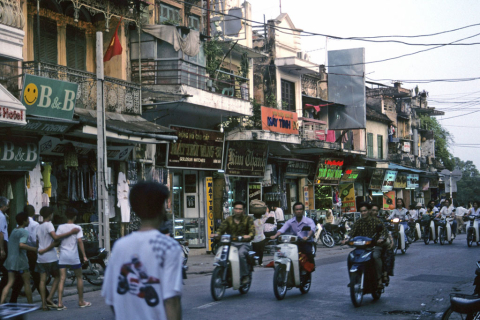 Old Quarter Hanoi commercial street with pedestrian and motorcycle traffic