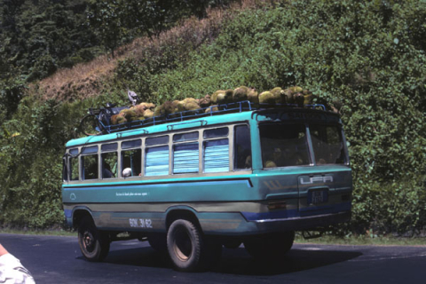 Bus with durian fruit on rooftop along road from Dalat to Ho Chi Minh City